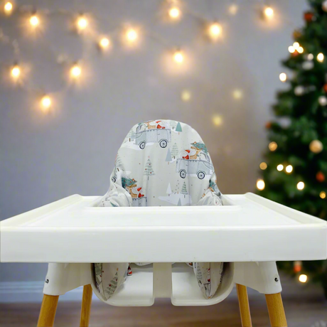 IKEA highchair with a christmas print cushion cover. Fairy lights and a christmas tree softly blurred in the background