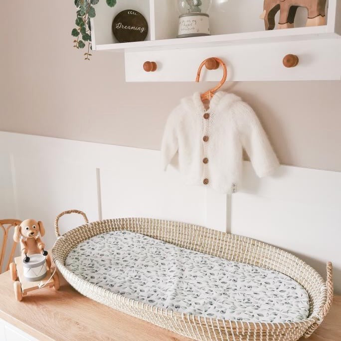 nursery picture of a baby changing basket with a eucalyptus print basket liner