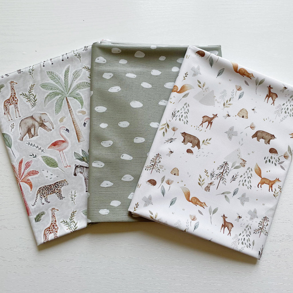 3 different baby splash mats from bobbin and bumble. One with sage dots, one jungle animal print and a woodland animal print. 